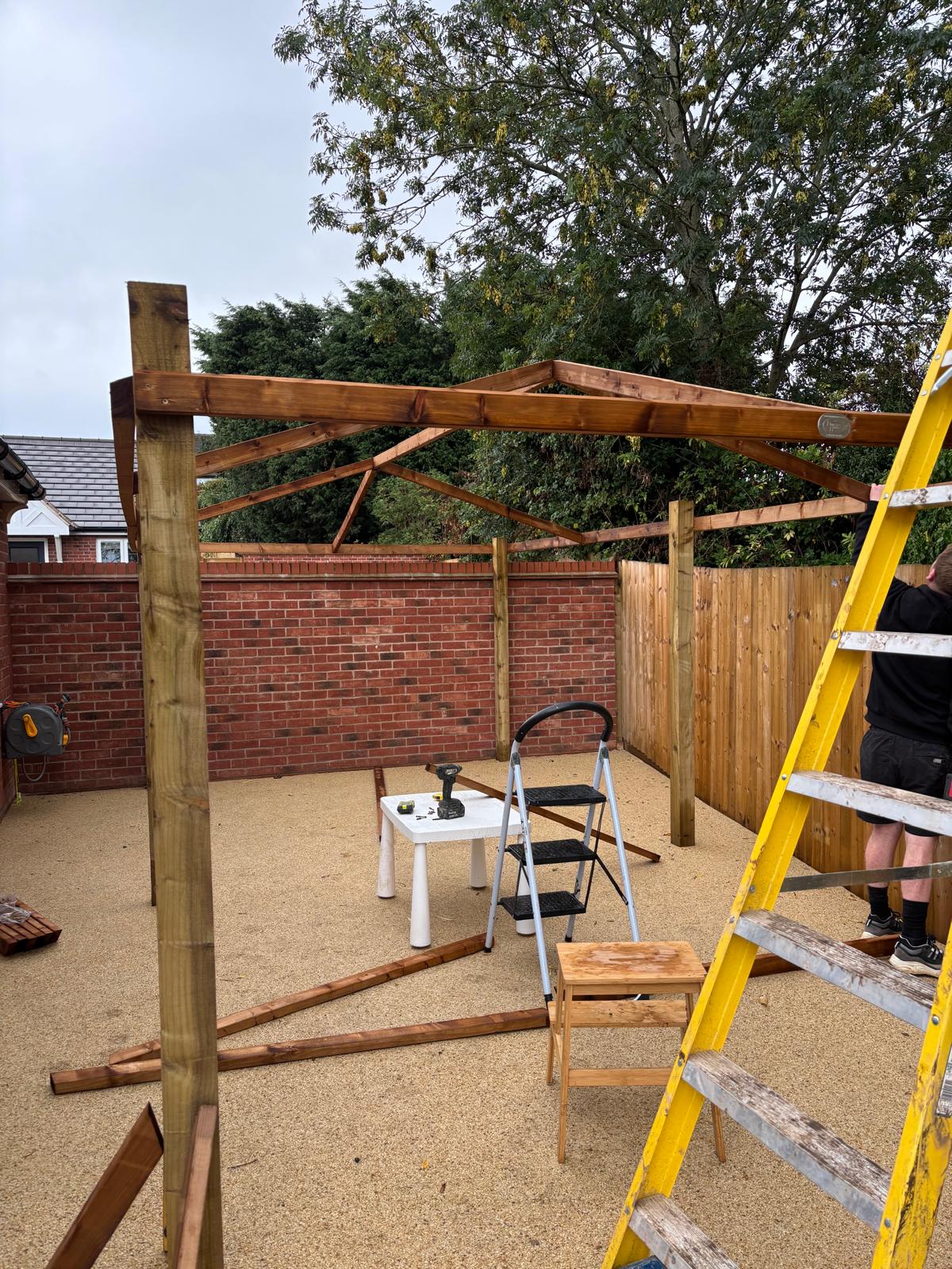 2f41d976-a58a-4e61-ac3b-6c262350708e Pergola being built over resin bound surfacing in the back garden of a house in Glasgow